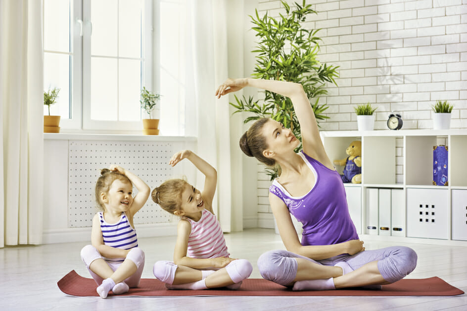 Mother and two children doing yoga together.